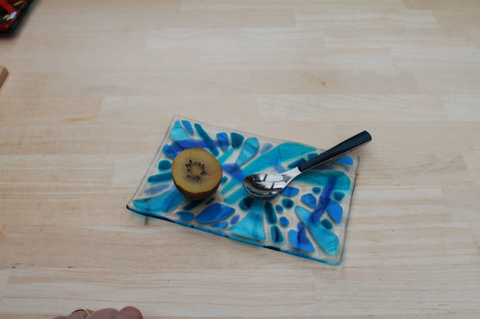 Plateau en verre artisanal bleu et blanc avec motifs abstraits, décoration artisanale éco-responsable.