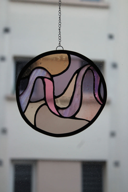 Vitrail rond en verre coloré artisanal aux formes ondulées, œuvre unique en artisanat d'art éco-responsable.