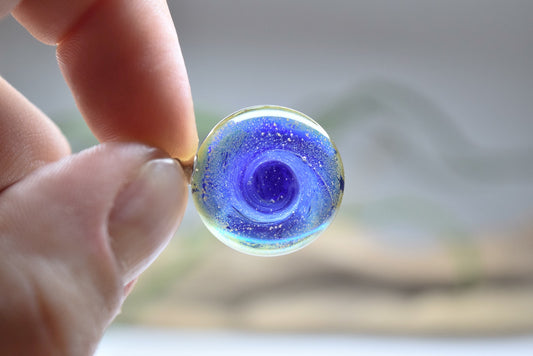 Pendentif rond en verre Murano bleu avec motifs tourbillonnants, bijou fait main et œuvre unique d'artisanat d'art écologique.