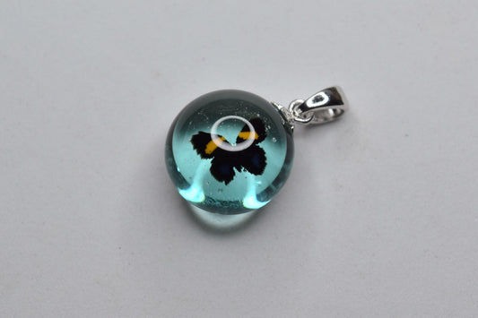 Pendentif artisanal en verre Murano rond avec décoration fleurie, bijou fait main unique, produit éco-responsable.