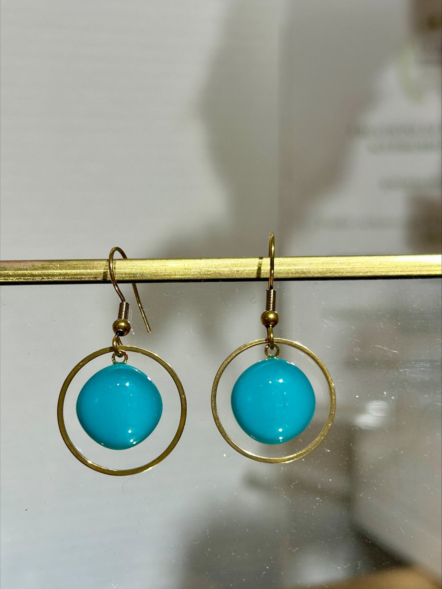 Boucles d'oreilles artisanales en métal doré avec perles turquoise, bijou fait main unique éco-responsable.