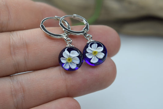 Créole artisanale en verre bleu avec fleur de narcisse blanche délicate, bijou fait main éco-responsable.