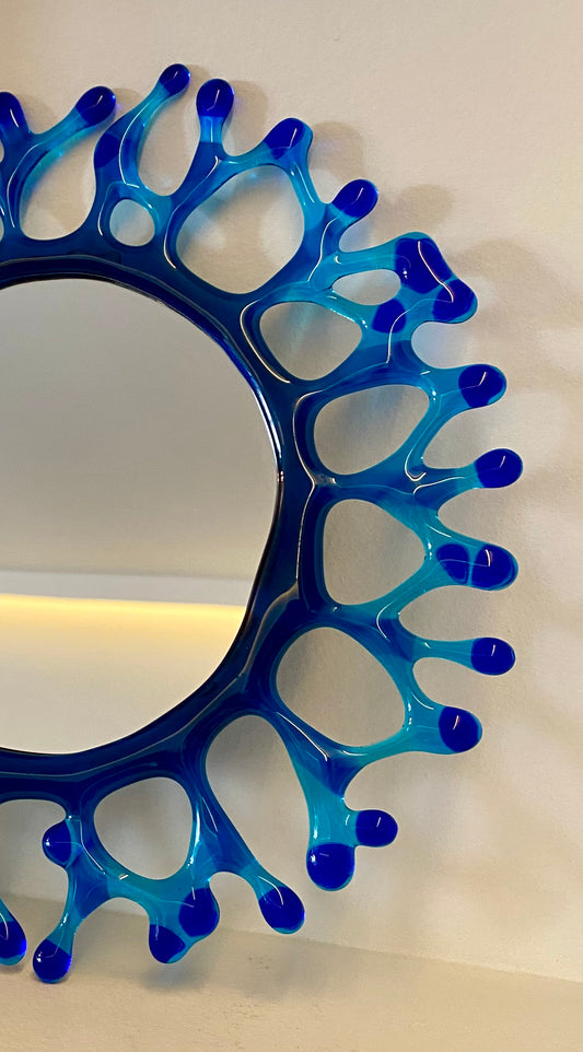 Miroir rond en verre bleu avec cadre corail artisanal, décoratif et éco-responsable, œuvre unique.