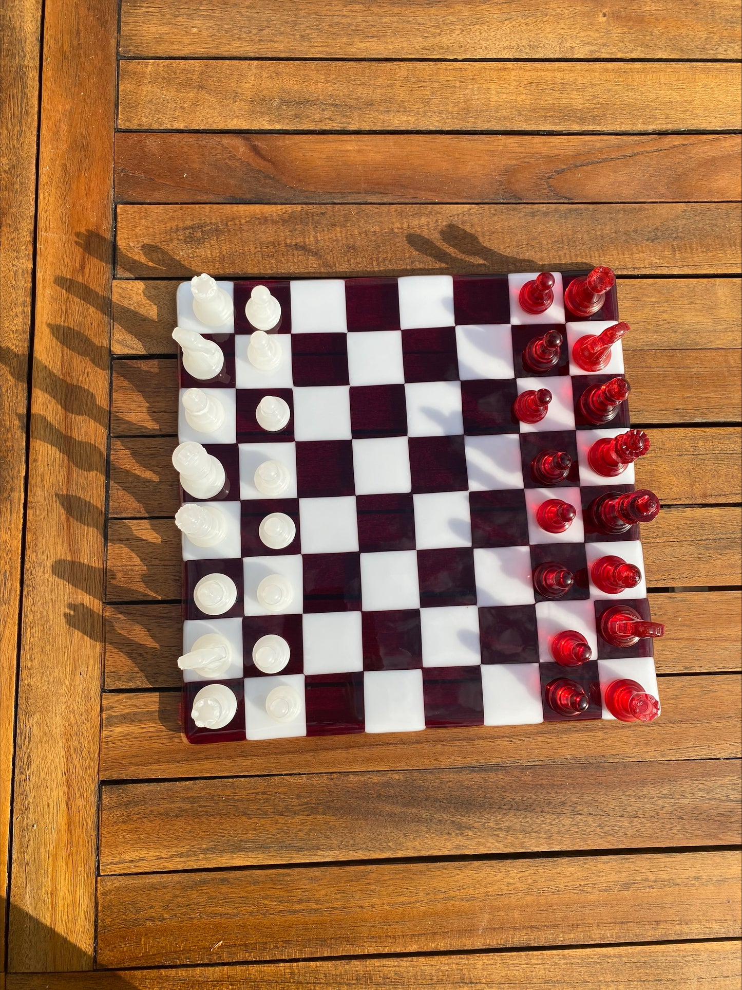 Échiquier en verre artisanat d'art avec pièces rouges transparentes et blanches opaque, création artisanale unique.