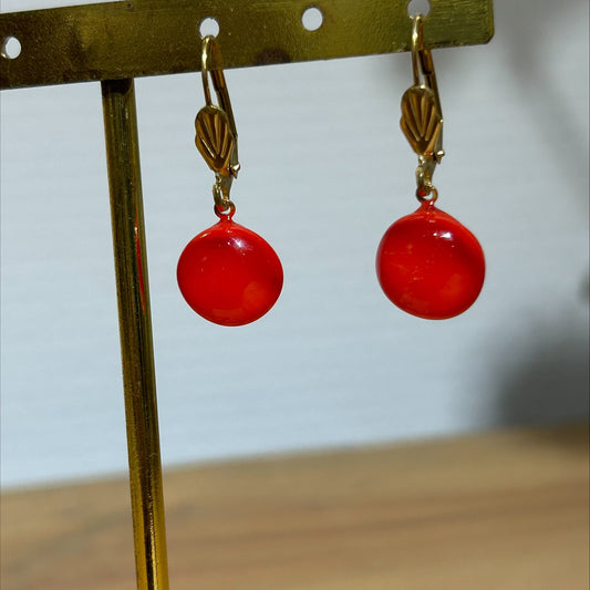 Boucles d'oreilles artisanat d'art en métal doré avec perles rouges translucides, bijou fait main et produit éco-responsable.