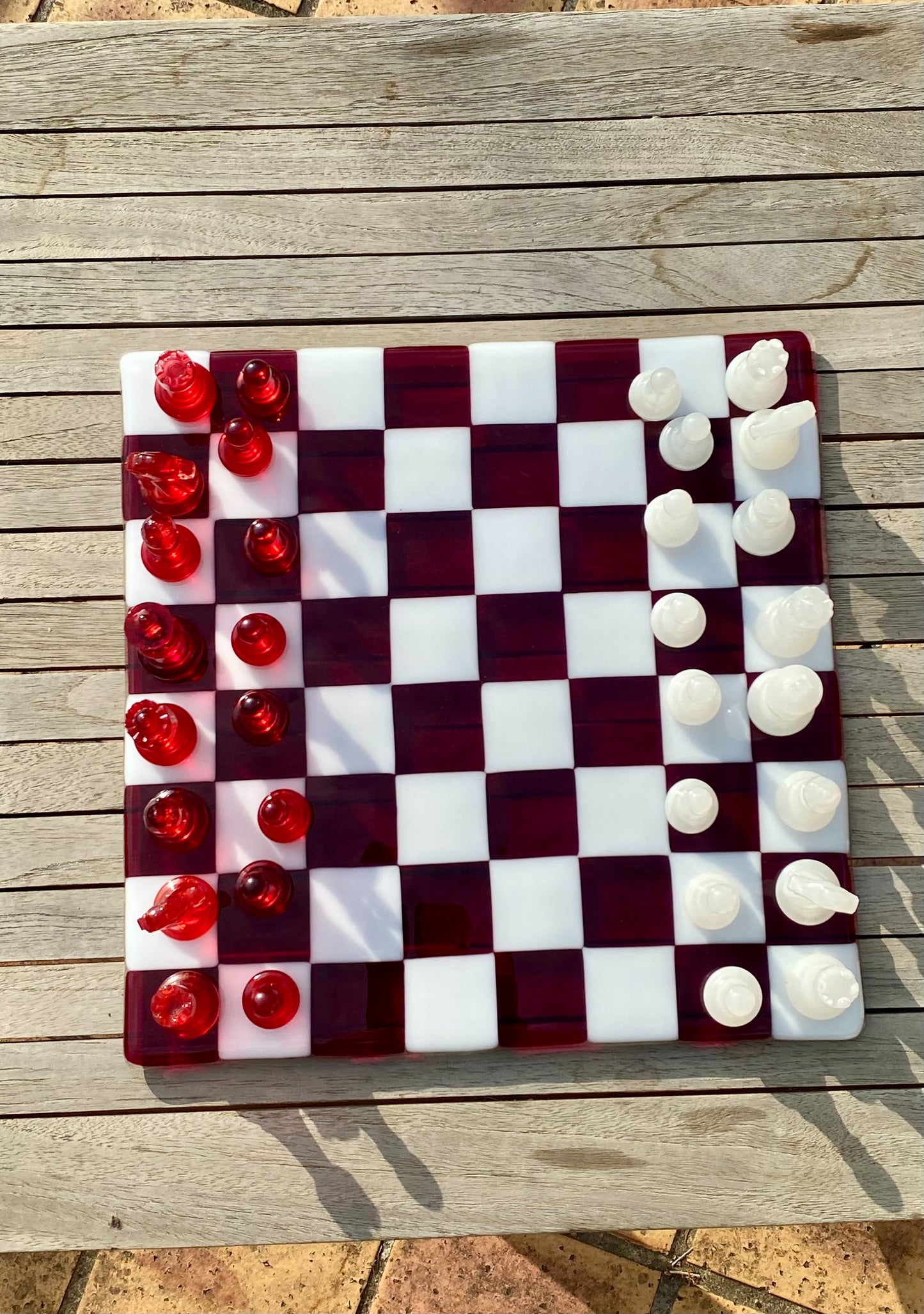 Échiquier en verre artisanat d'art avec pièces rouges transparentes et blanches opaque, création artisanale unique.