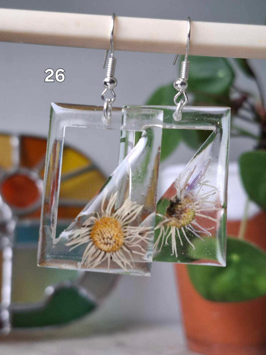 Boucles d’oreilles artisanales avec fleurs séchées encapsulées dans résine claire, bijou fait main unique et éco-responsable.