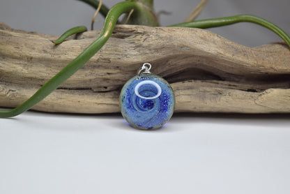Pendentif rond en verre Murano bleu avec motifs tourbillonnants, bijou fait main et œuvre unique d'artisanat d'art écologique.