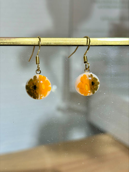 Boucles d'oreilles artisanales en résine translucide jaune et noire, bijou fait main, œuvre unique éco-responsable.
