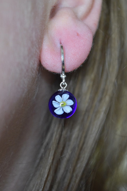 Créole artisanale en verre bleu avec fleur de narcisse blanche délicate, bijou fait main éco-responsable.