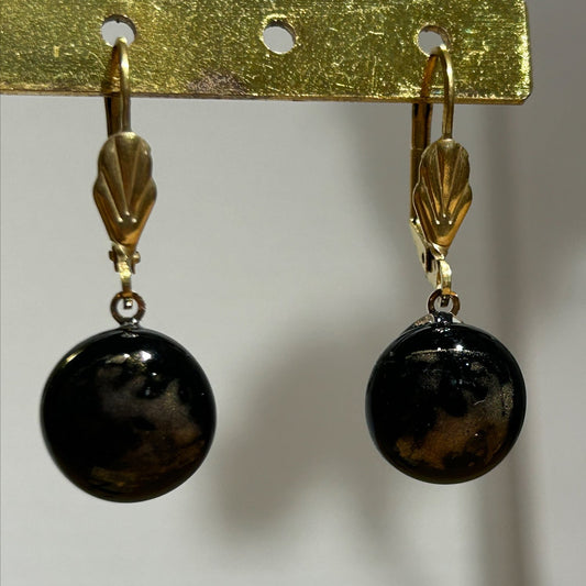 Boucles d'oreilles artisanales en métal doré et perles noires brillantes, bijou fait main, œuvre unique, produit.